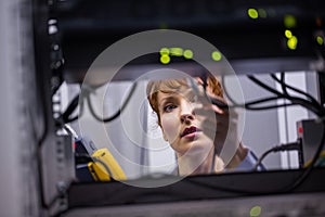 Technician using digital cable analyzer on server