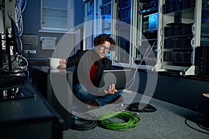 IT technician using laptop while working in data center