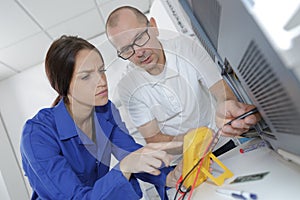 Technician using mutlitmeter on server in large data center