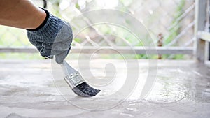 Technician using a varnish paint with a cement floor