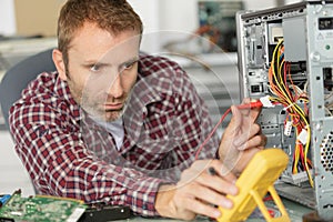 Technician using voltage meter for computer