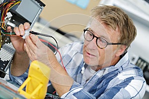 technician using voltage meter for voltage measurement in computer