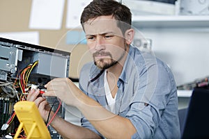 technician using voltage meter for voltage measurement in computer