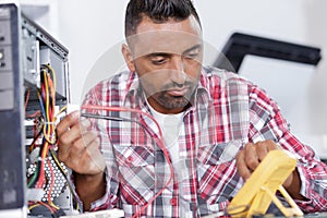 technician using voltage meter for voltage measurement in computer