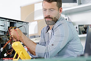 technician using voltage meter for voltage to fix pc