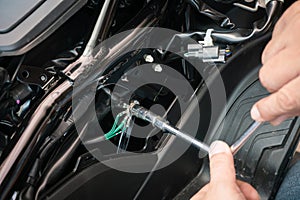 Technician using wrench tools to tighten bolts the ground wire on motorcycle,motorcycle maintenance and repair concept . selective