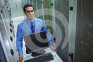 Technician walking with personal computer in hallway