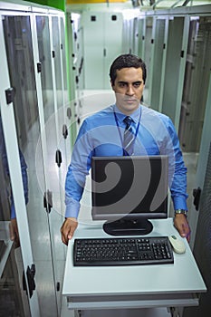 Technician walking with personal computer in hallway