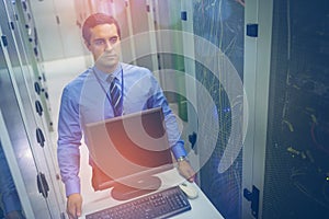 Technician walking with personal computer in hallway