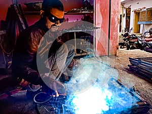 a technician welding on iron plate at factory in India January 2020