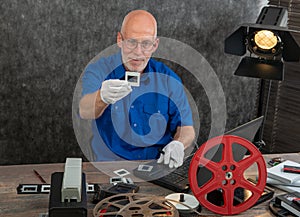 Technician with white gloves digitizing old 35mm film slide
