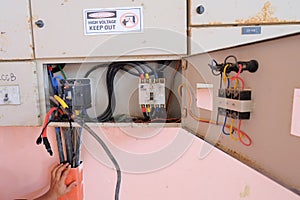 Technician wiring cable in front of electrical panel