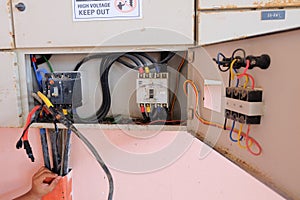 Technician wiring cable in front of electrical panel