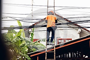 Technician on wooden ladder Checking Fiber Optic Cables. Technician on ladder is check and remove Digital Cable system