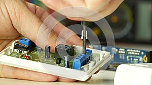 Technician work fixing connectors on a electronic board using a screwdriver