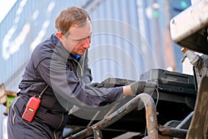 Technician or worker in cargo shipping check or maintenance truck in container area