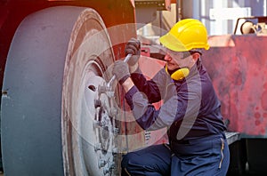 Technician worker man use wrench to fix nut of truck wheel in cargo container shipping area
