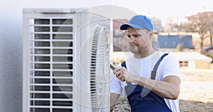 technician working on air conditioning or heat pump outdoor unit. HVAC service