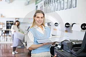 Technician working on plotter and cutter machine in printing shop