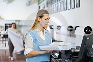 Technician working on plotter and cutter machine in printing shop