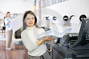 Technician working on plotter and cutter machine in printing shop