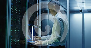 Technician works on a laptop in a data center