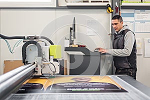 Technician works on large CNC computer numerical control cutting machine