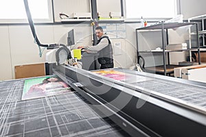 Technician works on large CNC computer numerical control cutting machine