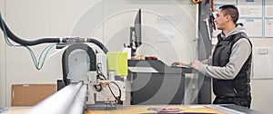 Technician works on large CNC computer numerical control cutting machine