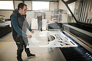 Technician works on Laser CNC computer numerical control cutting machine