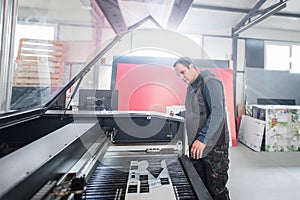 Technician works on Laser CNC computer numerical control cutting machine