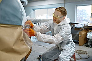 Technician wrapping car with paper before painting