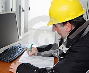 Technician writing data in the power plant control center