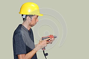 Technician with yellow helmet standing and driller in hand on clear background. clipping path