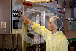 Technician young man adjust control panel of machine in factory for optimal performance. photo