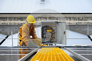 Technician Young Wearing Safety Protective Clothing and Safety Belt to Checking Wiring in Control Panel on Top Roof with Detail in