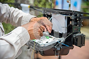 Technicians install cabinet on fiber optic cable.