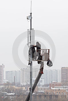 Technicians install mobile signal amplification devices on tower. It`s nasty. Unrecognizable people. Technology concept, 5G,