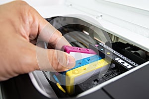 Technicians are install setup the ink cartridge of a inkjet printer the device of office automate for printing