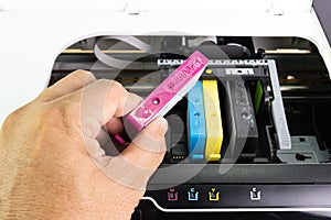 Technicians are install setup the ink cartridge of a inkjet printer the device of office automate for printing