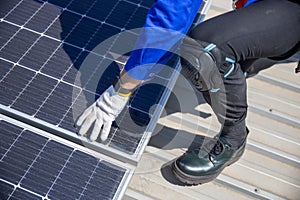 Technicians are installing and inspecting standards of solar panels on roof of an industrial factory. Electrical energy obtained