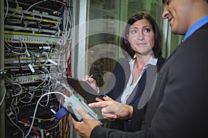 Technicians interacting with each other while analyzing server