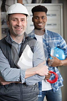 technicians posing next to fuseboard