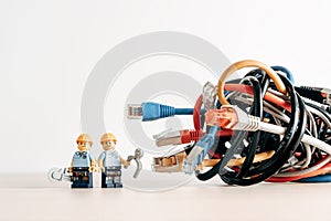 Technicians and a tangled bunch of network cables. Illustrative editorial. Illustrative editorial