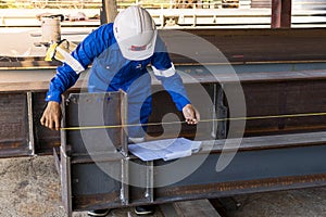 Technicians are using measuring tape to checking the accuracy of the steel structure