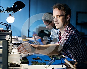 Technicians working on electronics parts photo