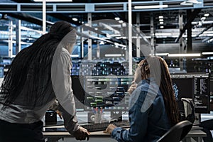 Technicians working together programming in server farm