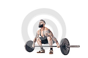 The technique of doing an exercise of deadlift with a barbell of a muscular strong tattooed bearded sports men on a