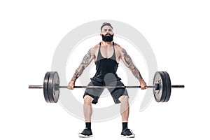 The technique of doing an exercise of deadlift with a barbell of a muscular strong tattooed bearded sports men on a