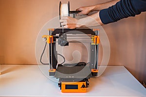 Technological hi-teg tool for making new things. A black and red 3D printer at work. The object is created by laying down